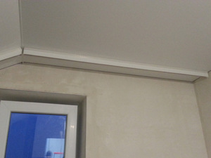 Белый матовый потолок мансардного типа с потолочным карнизом
